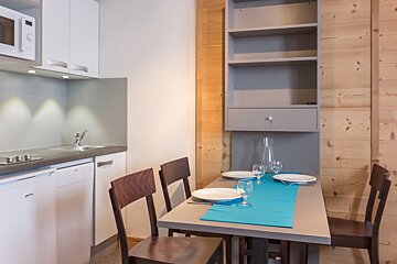 A small kitchen with a table and chairs and a microwave