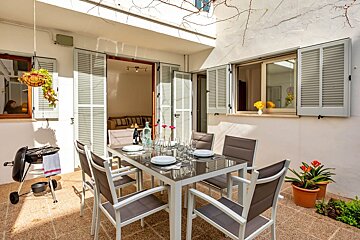 A patio with a table and chairs and a grill
