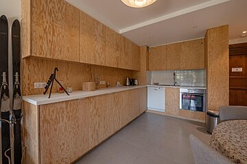 A kitchen with wooden cabinets and a few skis on the wall