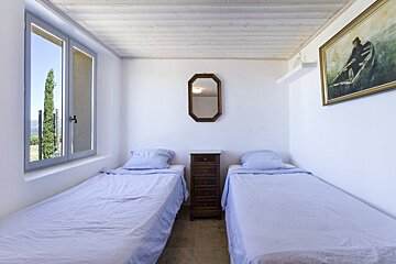 A bedroom with two beds and a painting on the wall