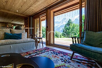 A living room with a couch and chair and a view of the mountains