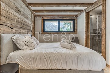 A bedroom with a bed and a window that says ten80