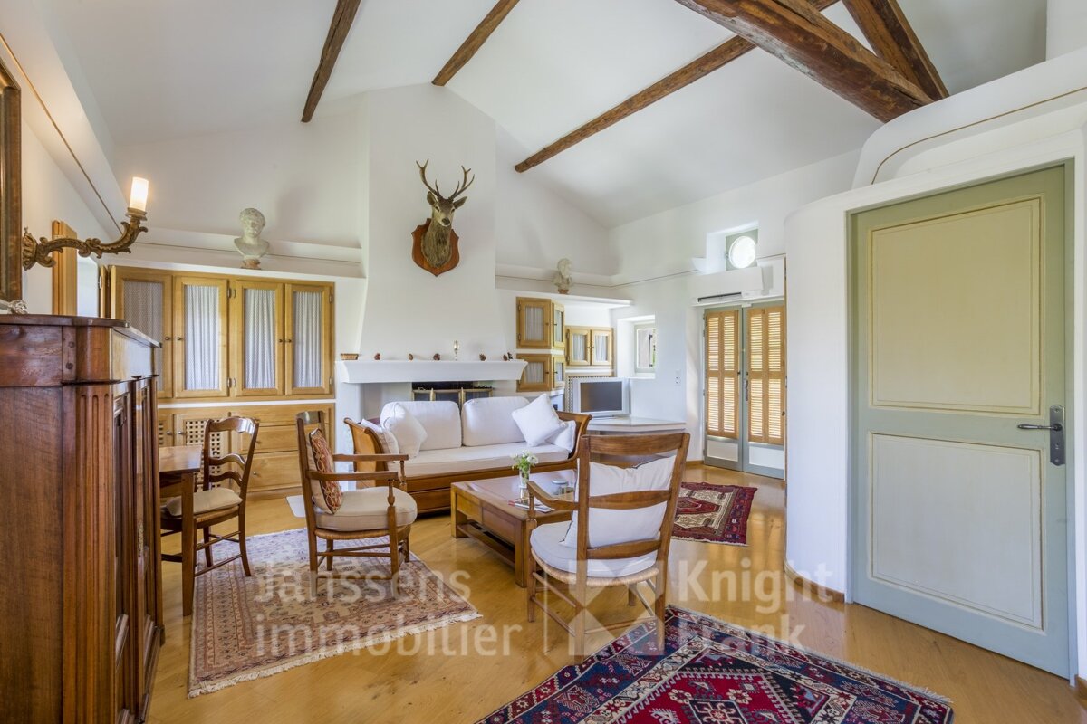 A living room with a couch and chairs and a sign that says janssens immobilier