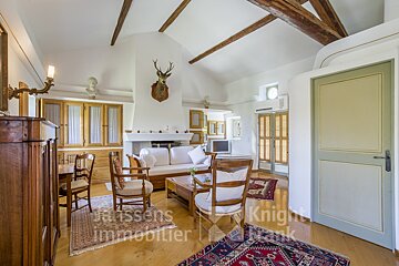 A living room with a couch and chairs and a sign that says janssens immobilier