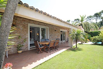 A patio with a table and chairs in front of a house