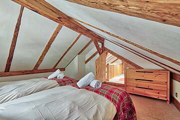 A bedroom with two beds and a wooden dresser