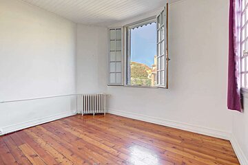 An empty room with a window and a radiator