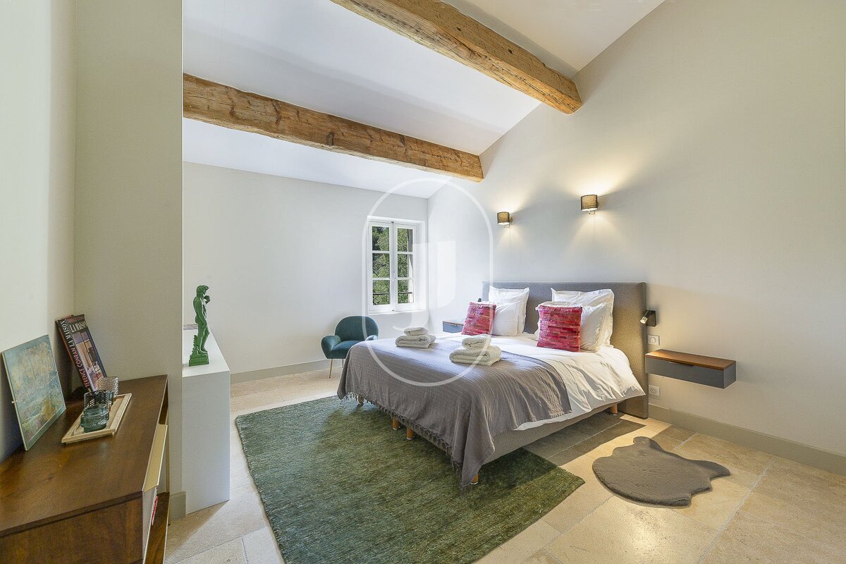 A bedroom with a large bed and a green rug