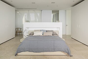 A bedroom with a bed and a chair in it