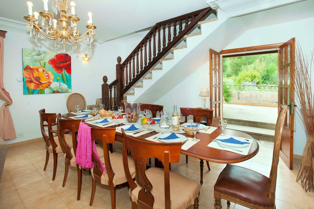 A dining room with a table and chairs and a chandelier