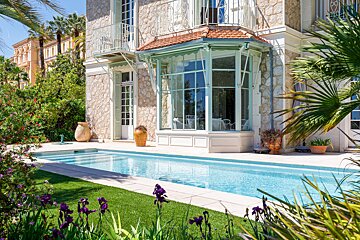 A large house with a swimming pool in front of it