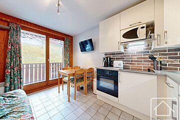 A kitchen with a table and chairs and a microwave