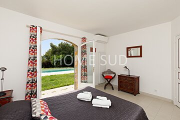 A bedroom with a view of a pool and the words home sud on the wall