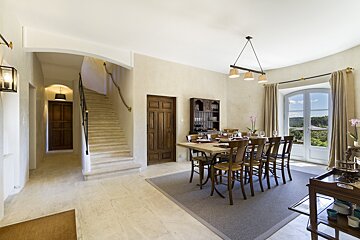 A dining room with a table and chairs and stairs
