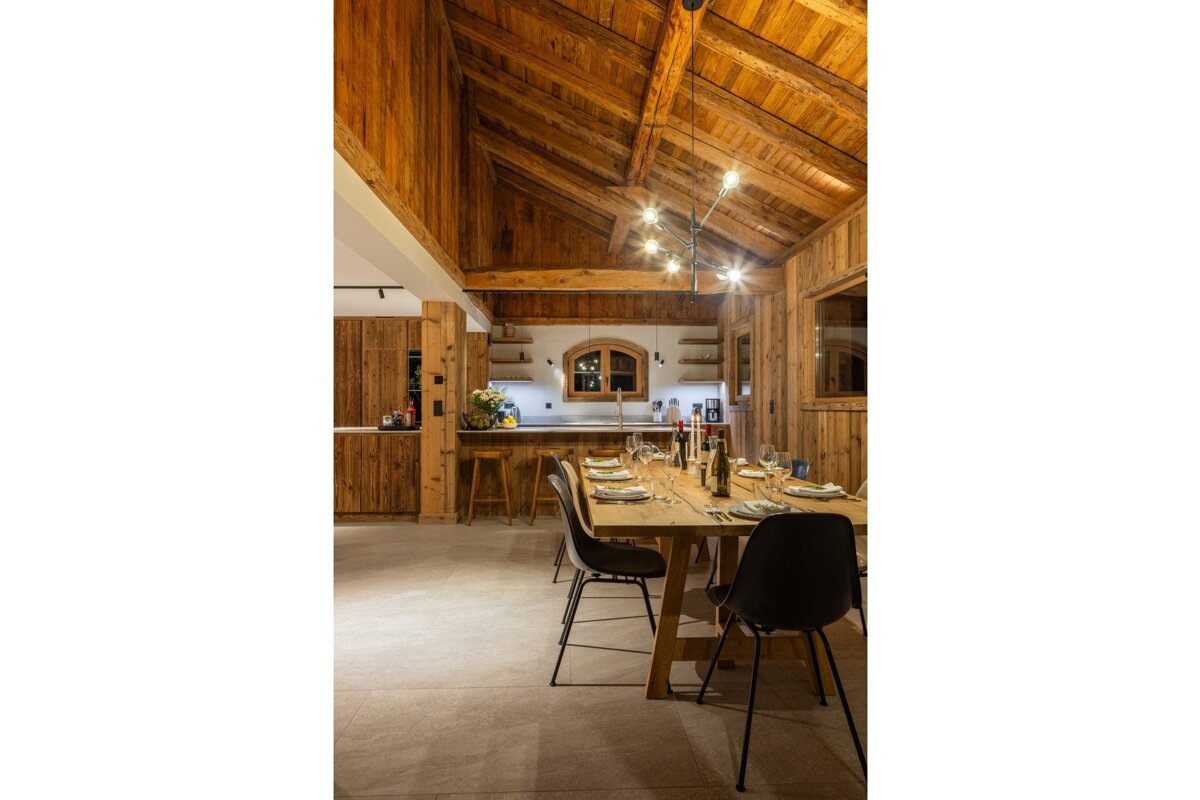 A dining room with a wooden table and chairs