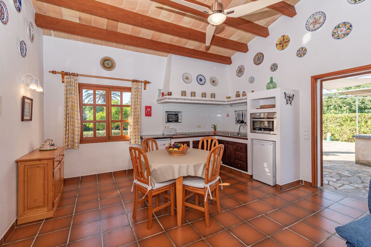A kitchen with a table and chairs and plates on the wall