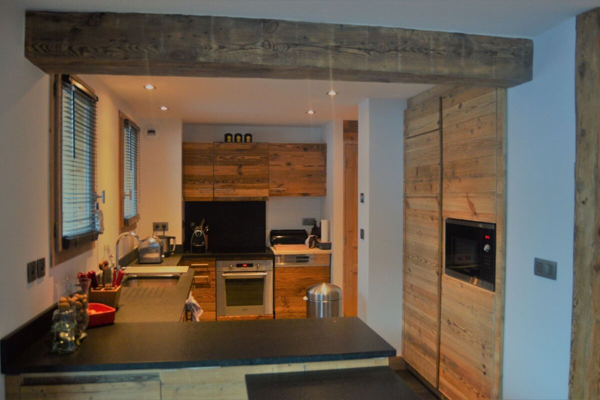 A kitchen with wooden cabinets and a black counter top