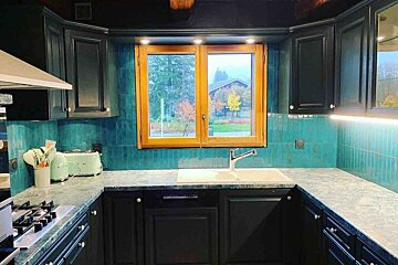 A kitchen with black cabinets and green counter tops
