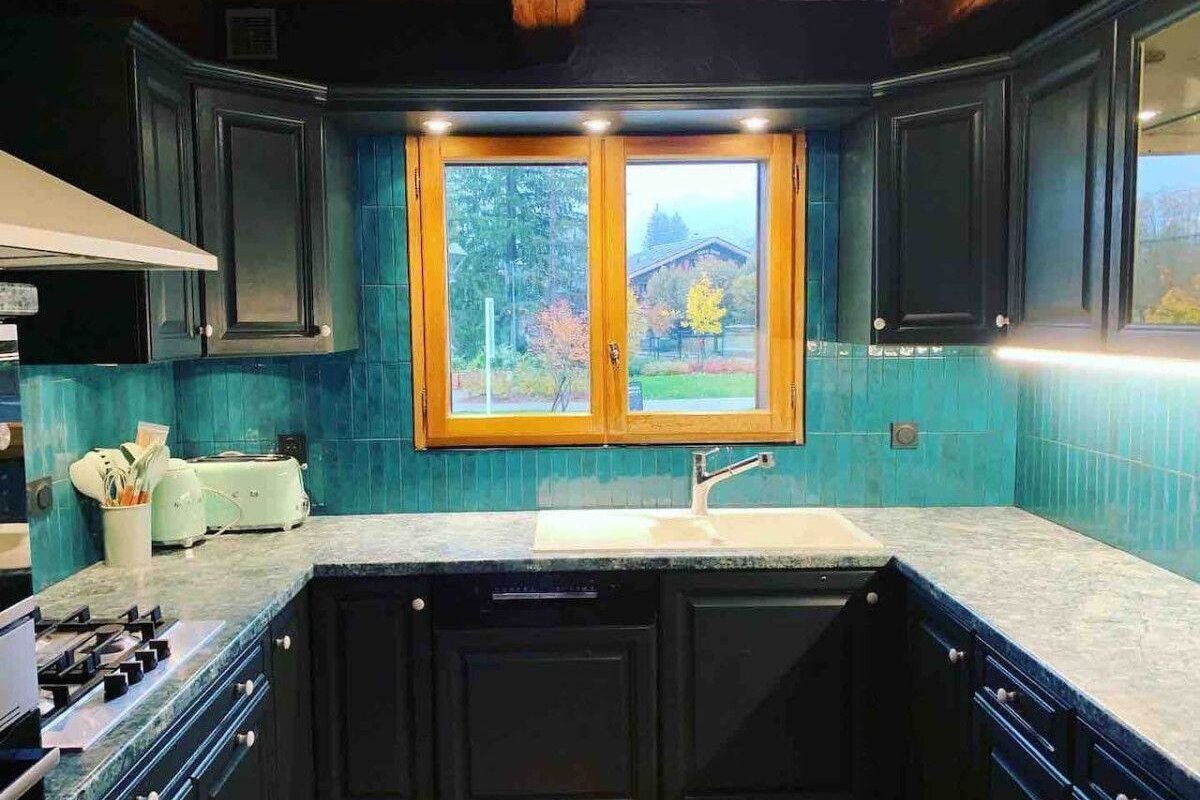 A kitchen with black cabinets and green counter tops