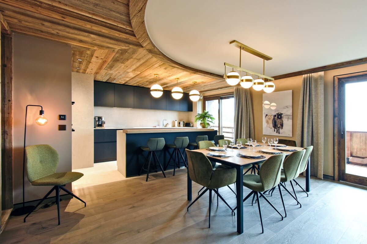 A dining room with a table and chairs and a picture of a cow on the wall