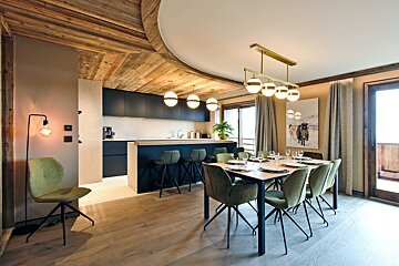 A dining room with a table and chairs and a picture of a cow on the wall