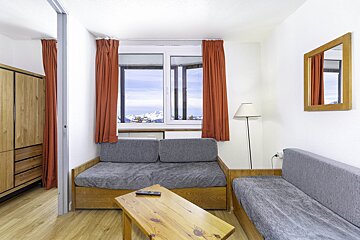 A living room with a couch a table and a window