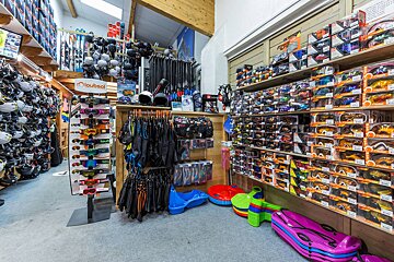 A store with lots of sunglasses and a sign that says