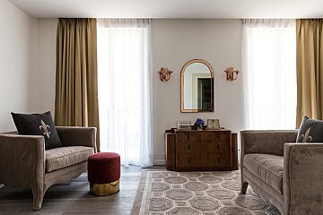 A living room with two chairs and a dresser