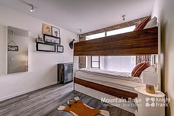 A bedroom with a bunk bed and a sign that says mountain base immobilier real estate