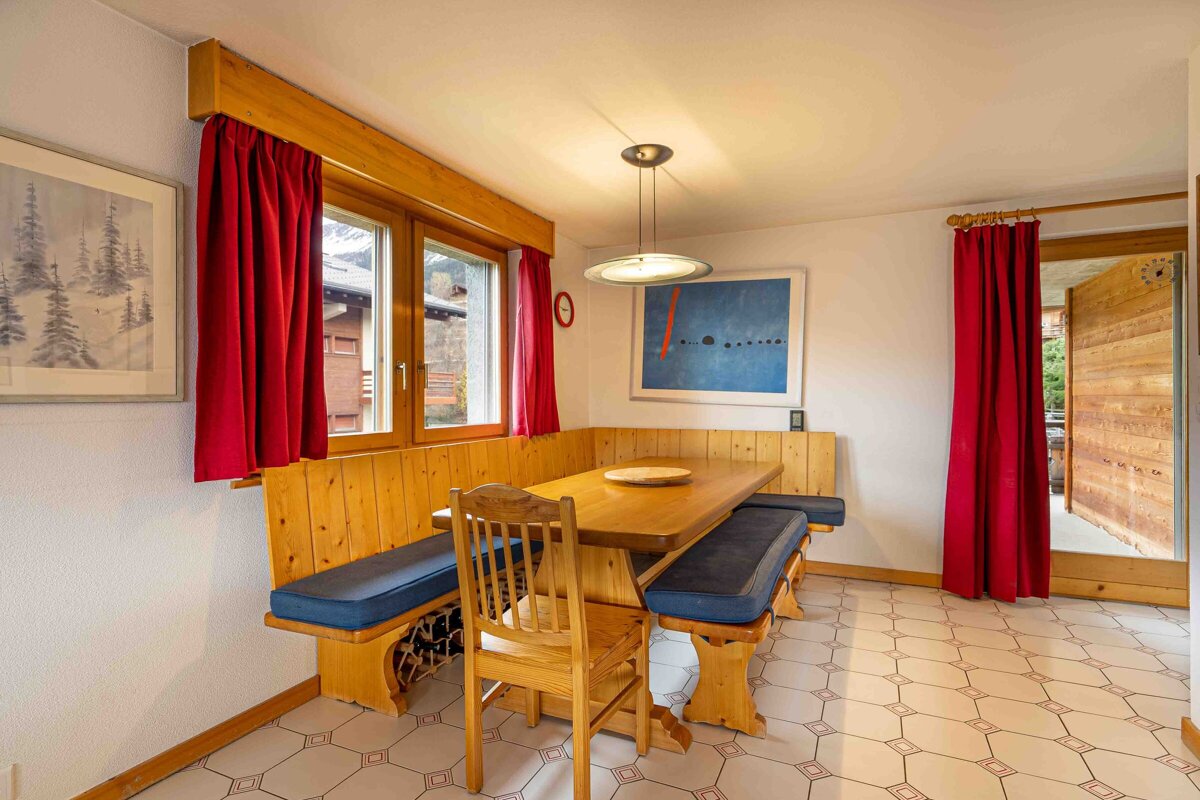 A dining room with a wooden table and benches