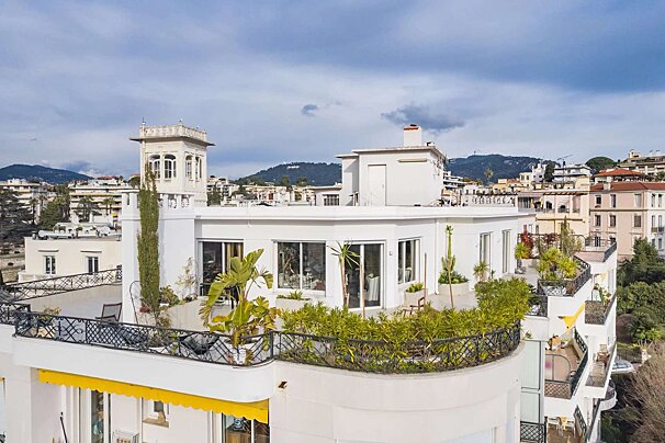 A white building with a yellow awning on the balcony