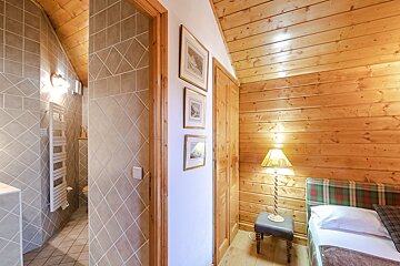 A bedroom with a single bed and a lamp