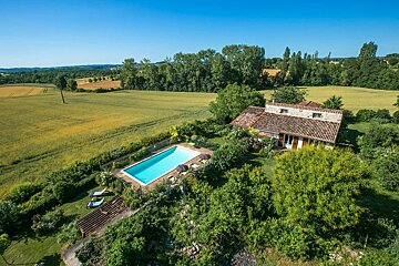 An aerial view of a house with a large swimming pool