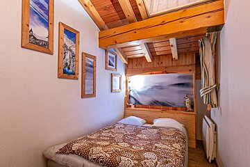 A bedroom with a bed and pictures on the wall