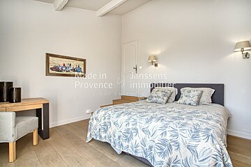 A bedroom with a bed and a picture on the wall that says made in provence