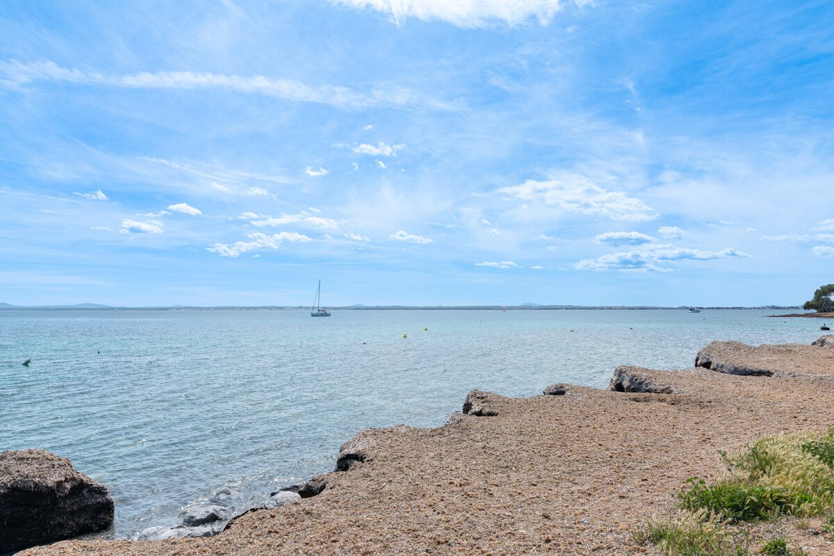 A large body of water with a sailboat in the distance