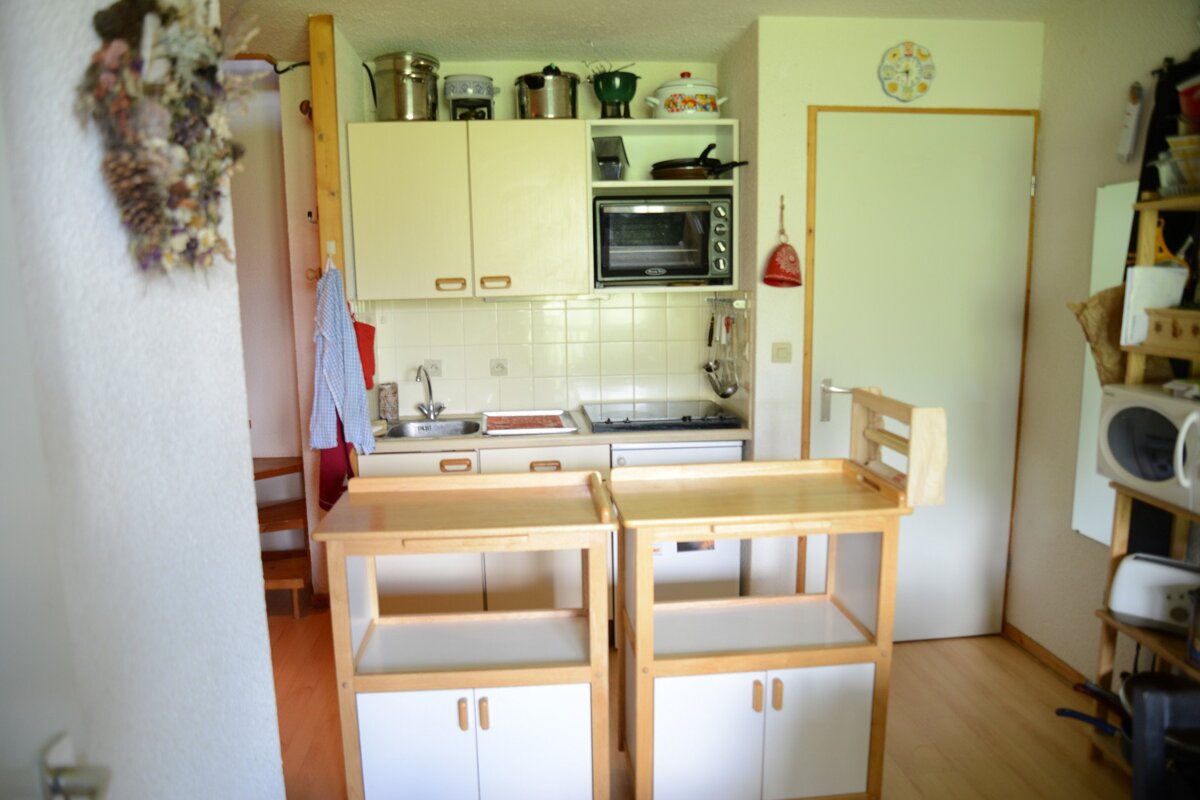 A small kitchen with a clock on the wall above the door