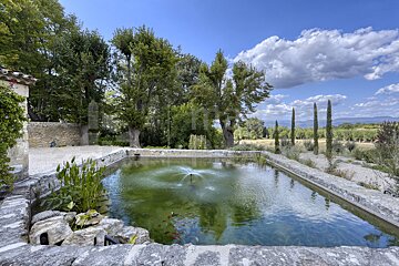 A large pond with a fountain in the middle of it