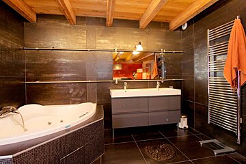 A bathroom with a bathtub and two sinks