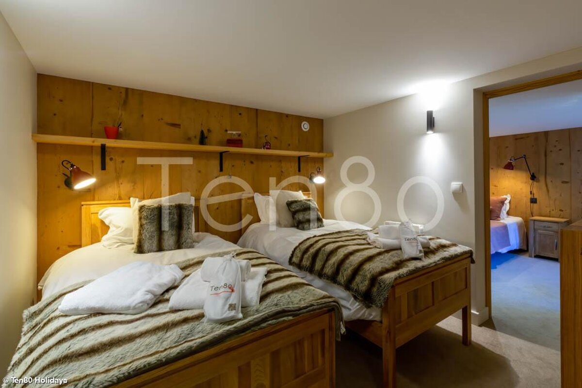 A bedroom with two beds and the number 80 on the wall