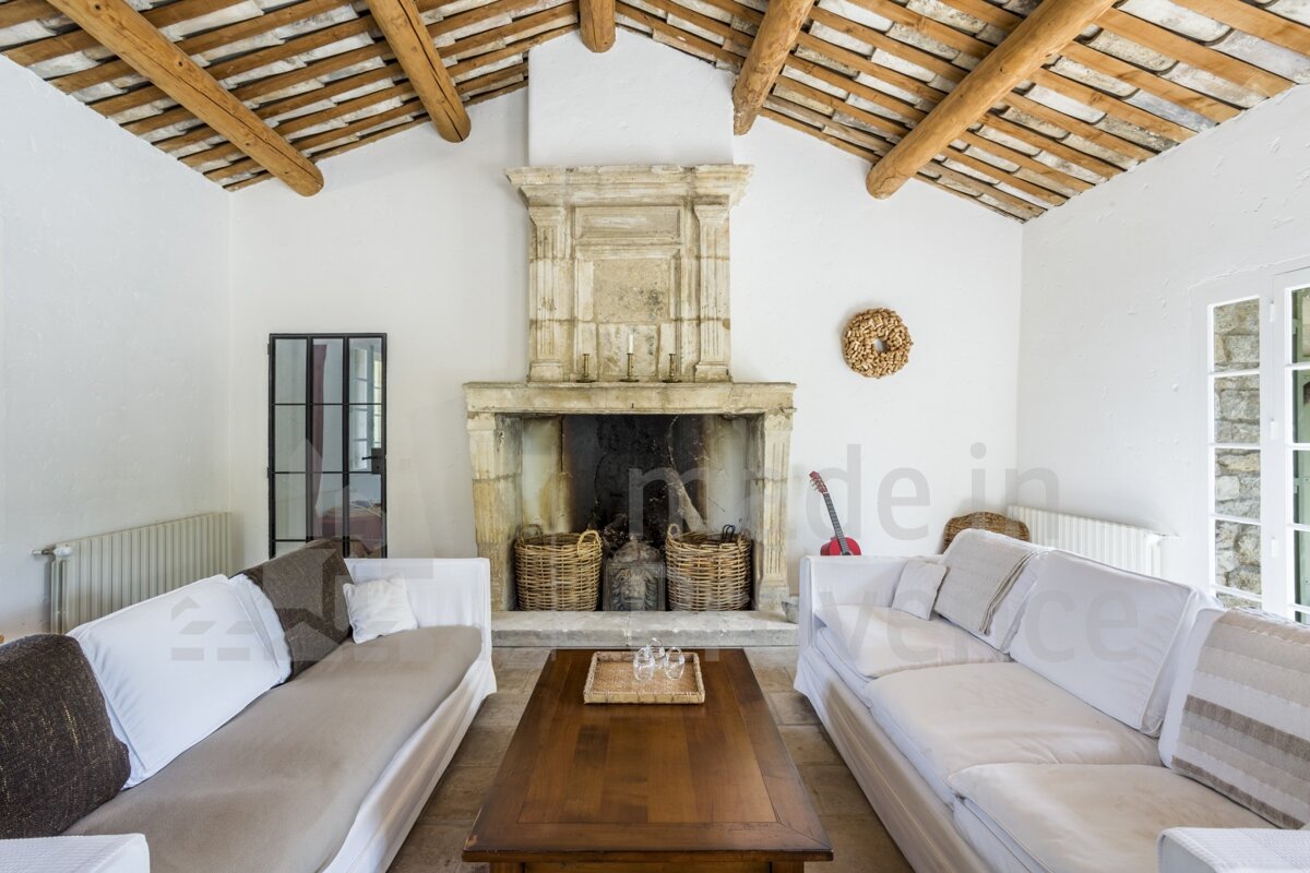 A living room with two couches and a fireplace with the word made in the corner