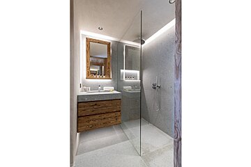 A bathroom with a walk in shower and a sink