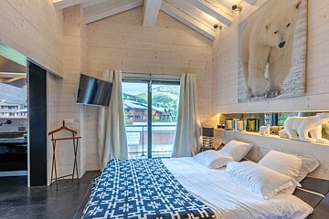 A bedroom with a large picture of two polar bears on the wall above the bed