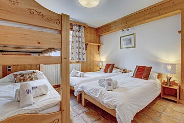 A bedroom with bunk beds and a picture on the wall