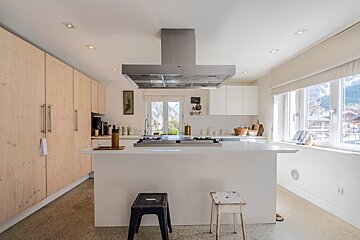 A kitchen with white cabinets and a stove top oven