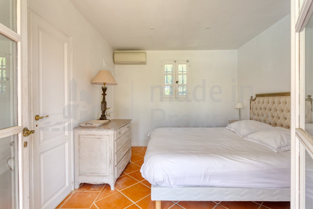 A bedroom with a bed and a dresser with the word made on the wall