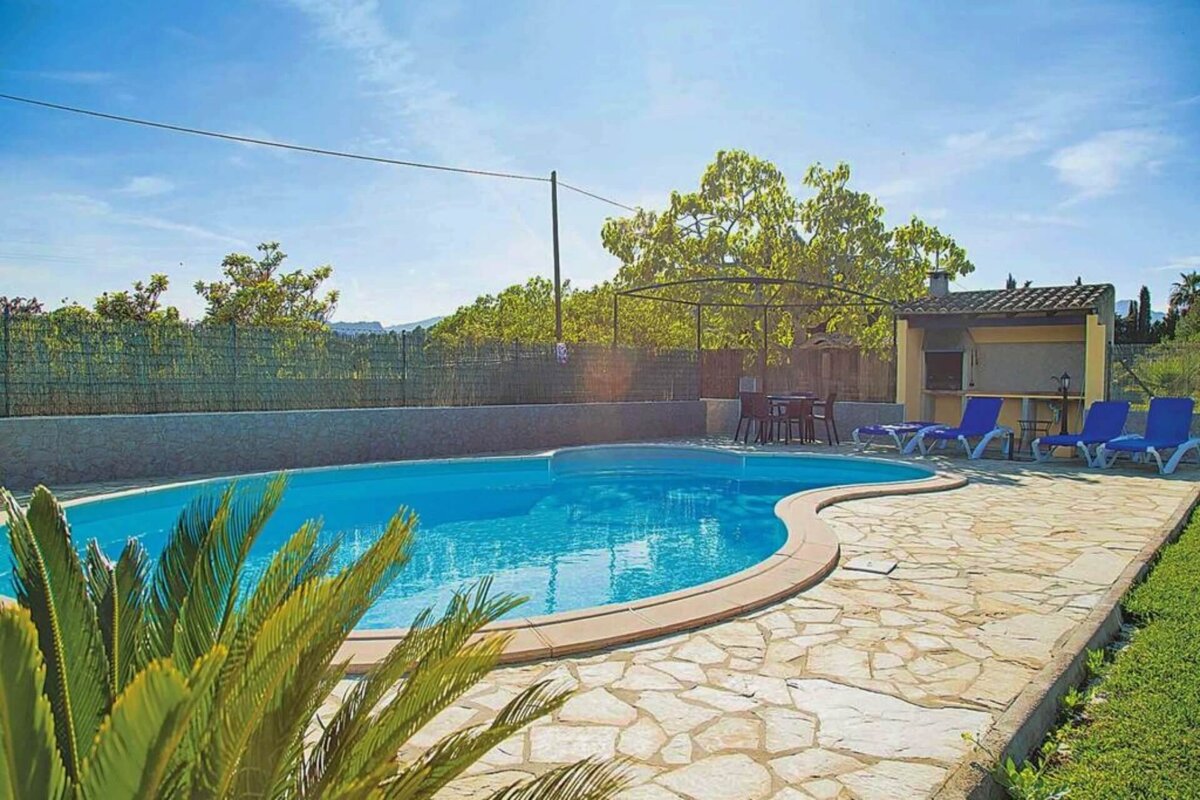 A large swimming pool surrounded by chairs and a fence