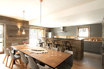 A dining room with a wooden table and chairs