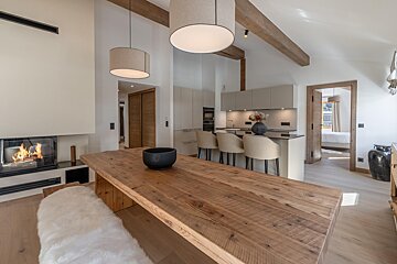 A kitchen with a wooden table and chairs and a fireplace