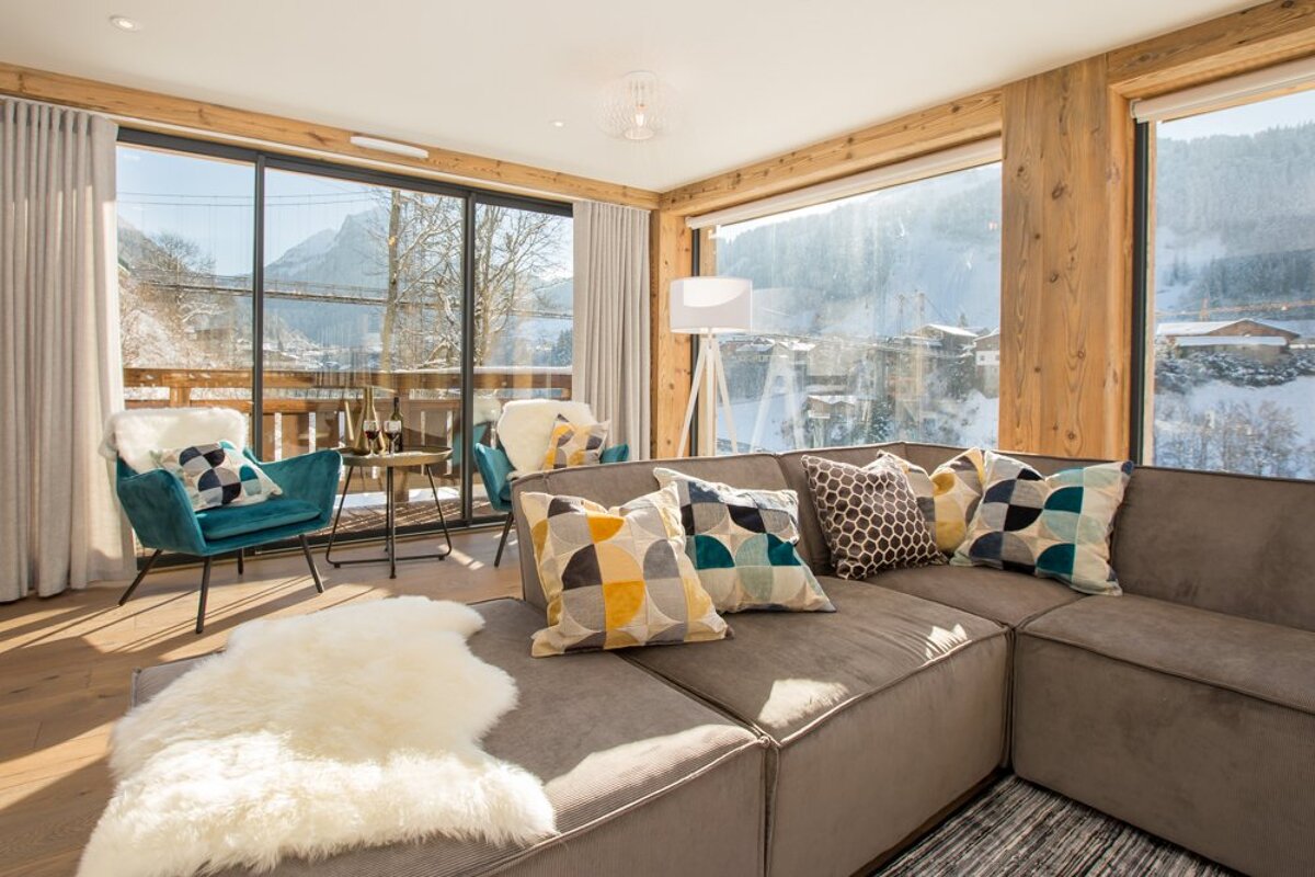 A living room with a couch and chairs and a view of the mountains